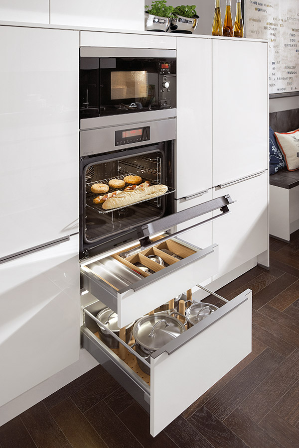Organiza los elementos de forma que puedas aprovechar la verticalidad también con los electrodomésticos, como por ejemplo colocando el microondas encima del horno cocinas estrechas
