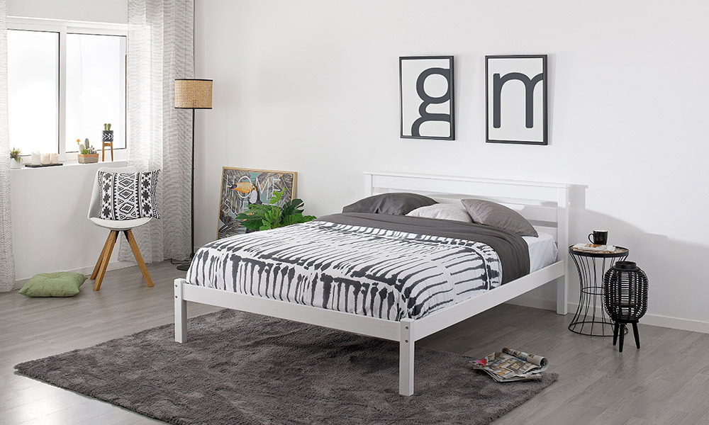La mesilla de metal negro y superficie de madera natural junto con una lámpara de pie son los complementos imprescindibles para un diseño rústico, sencillo y práctico, ideal para preparar la habitación de tus invitados. dormitorios rústicos