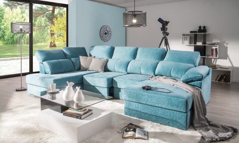 Salón con chaise longue azul e iluminación tipo industrial como iluminar un salon comedor
